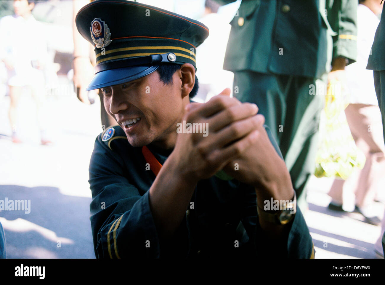 Chinese soldier laughing while clasping his hands together, China Stock Photo