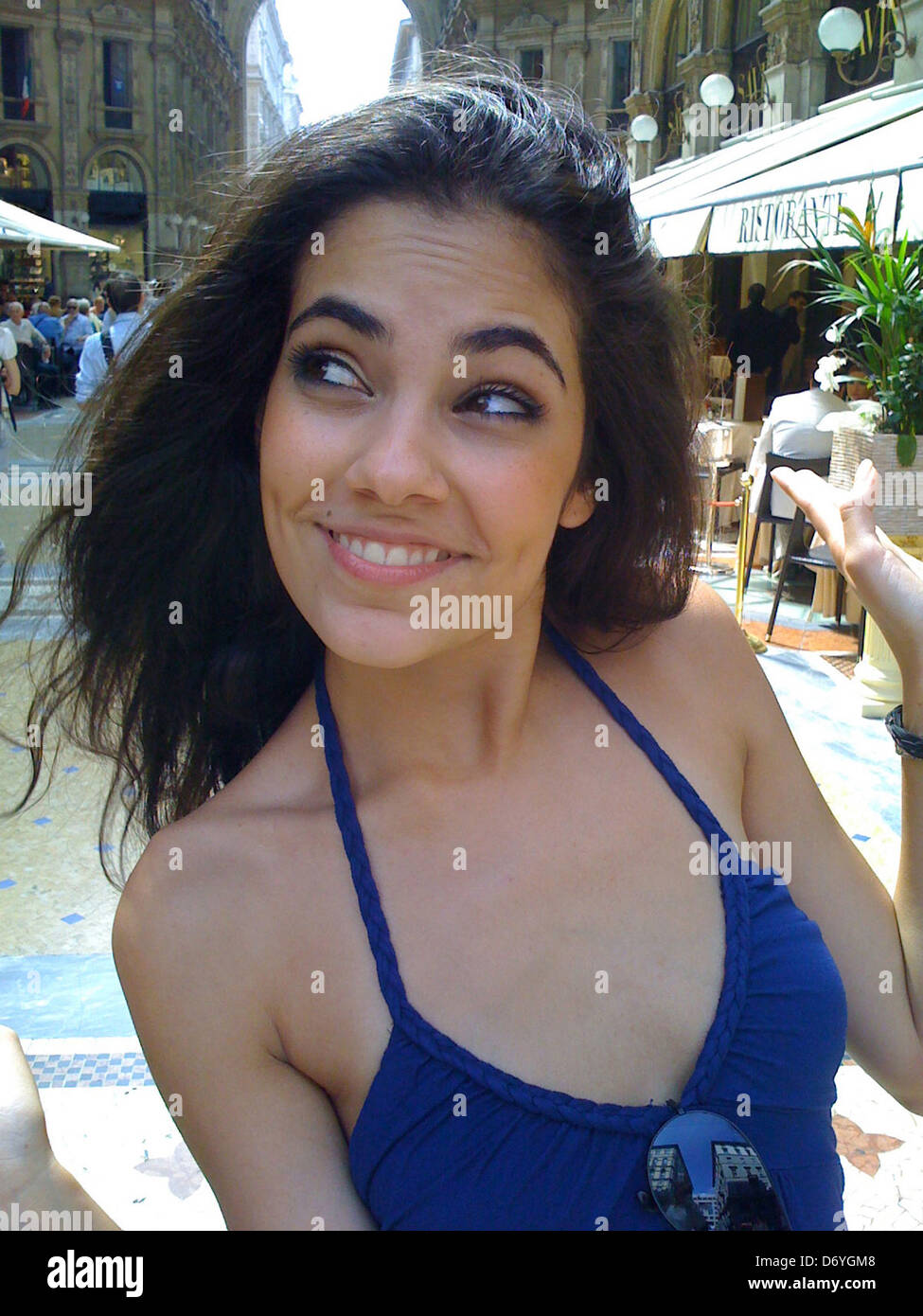 Smiling Hispanic woman on city street - Smartphone Captured Stock Image