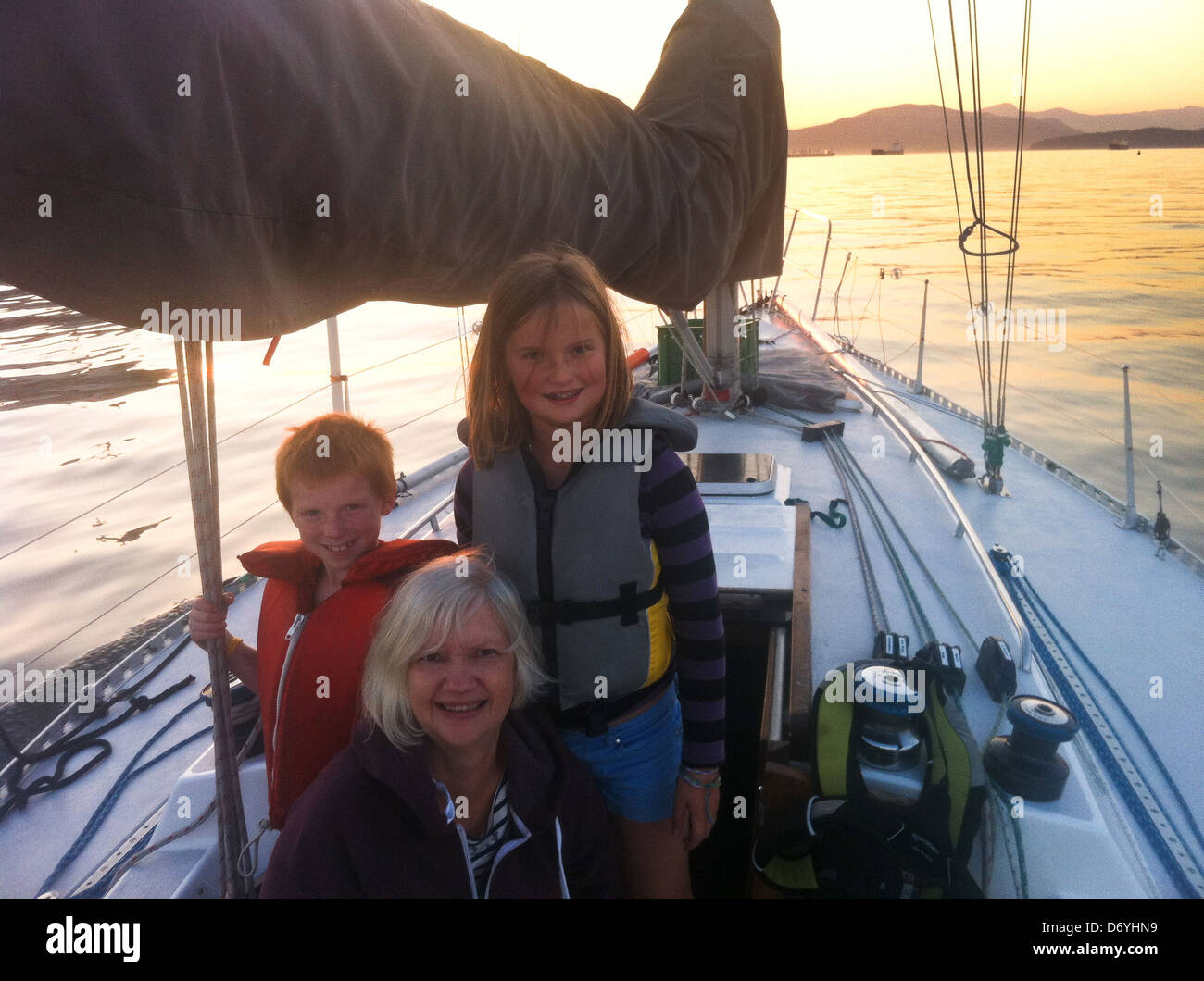 Caucasian grandmother and grandchildren on sailboat - Smartphone Captured Stock Image