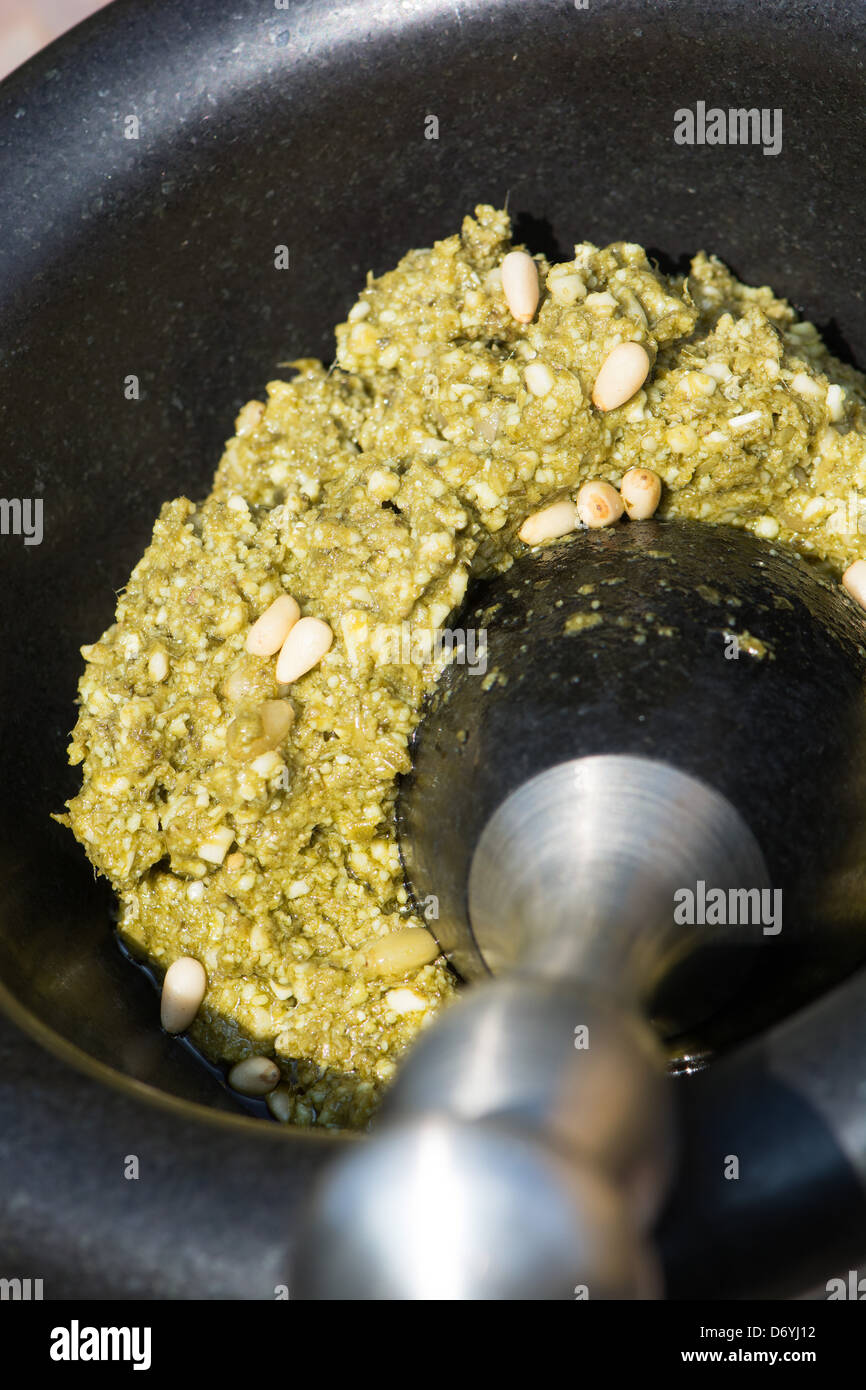 Pesto (fresh basil, extra virgin olive oil, Grana Padano cheese, pine nuts and salt) in a mortar with pestle. UK, 2013. Stock Photo