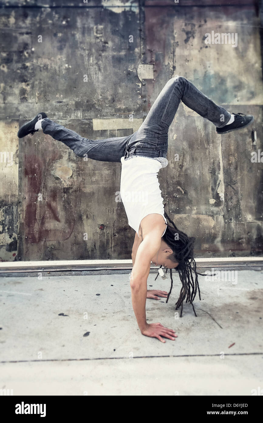 Chinese man doing handstand on sidewalk - Smartphone Captured Stock Image