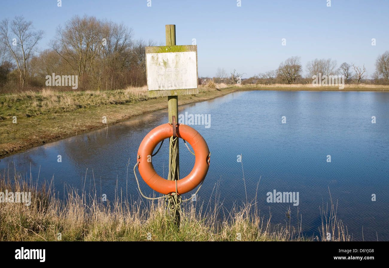 Orange life saving ring by irrigation water reservoir, Sutton, Suffolk, England Stock Photo