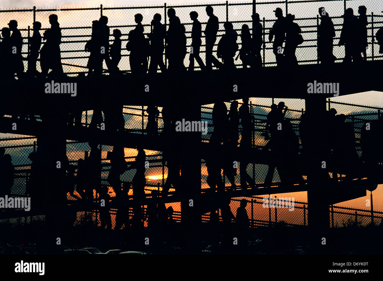 Silhouette of people walking down a ramp at sunset Stock Photo - Alamy