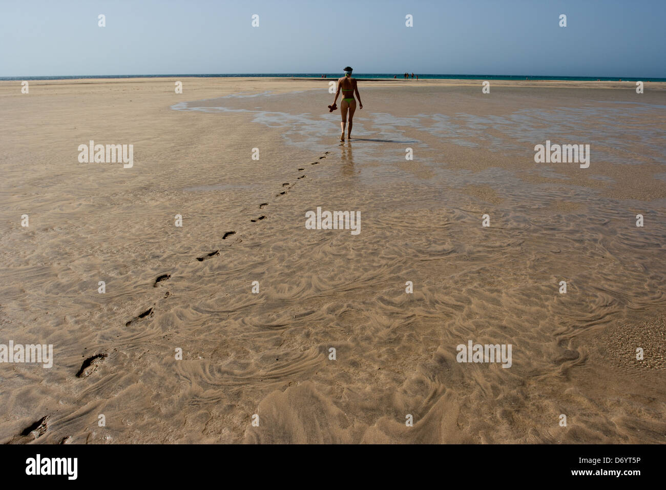 Woman walking alone along the beach in Fuerteventura Stock Photo
