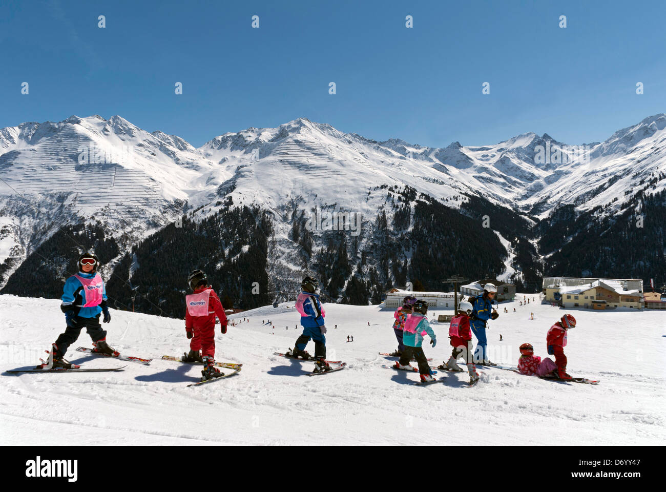 Class of young children learning to ski, on the slopes above St Anton, in the Tyrol region of Austria Stock Photo