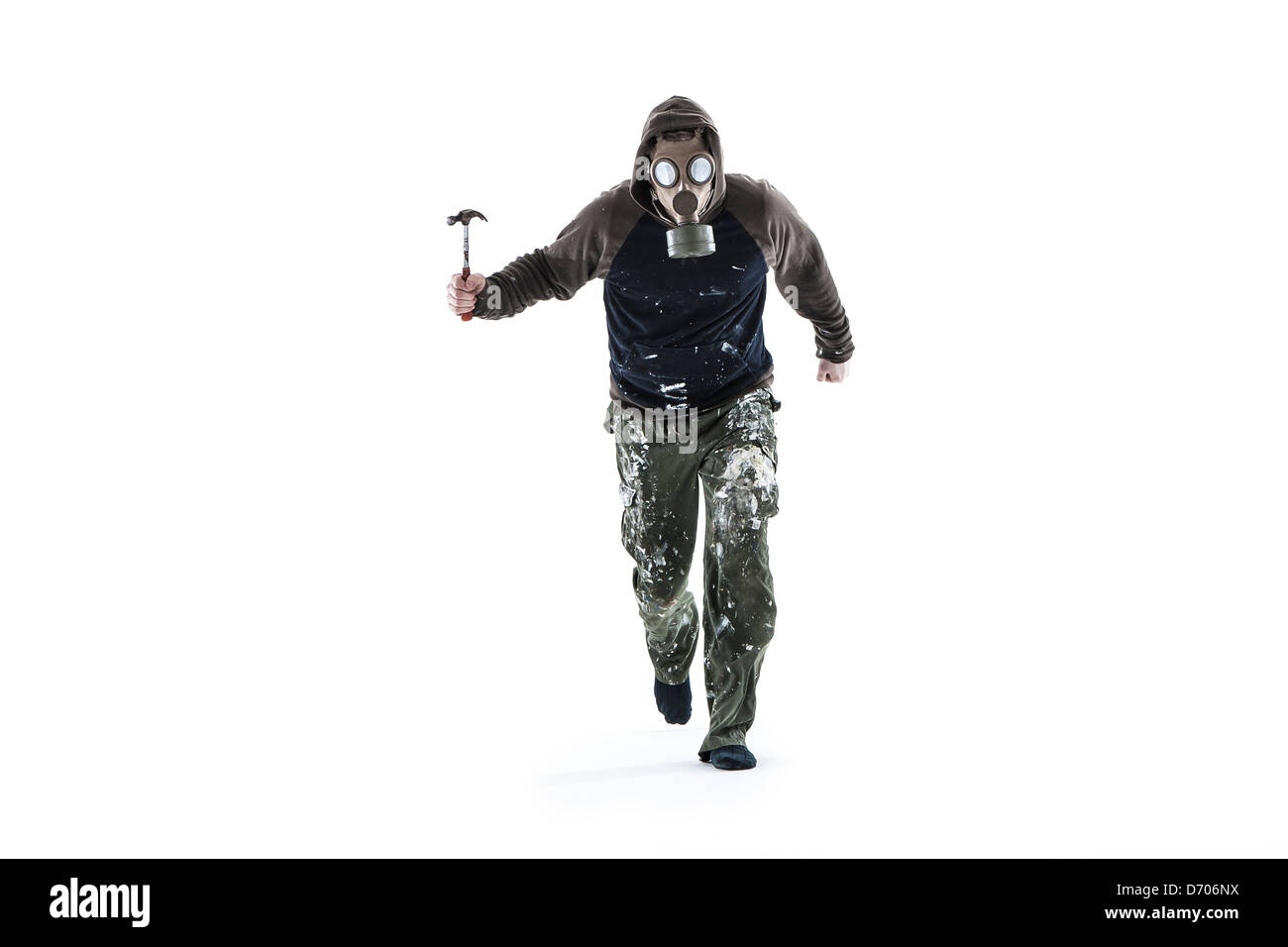 figure wearing a gas mask running towards camera wielding a hammer Stock Photo