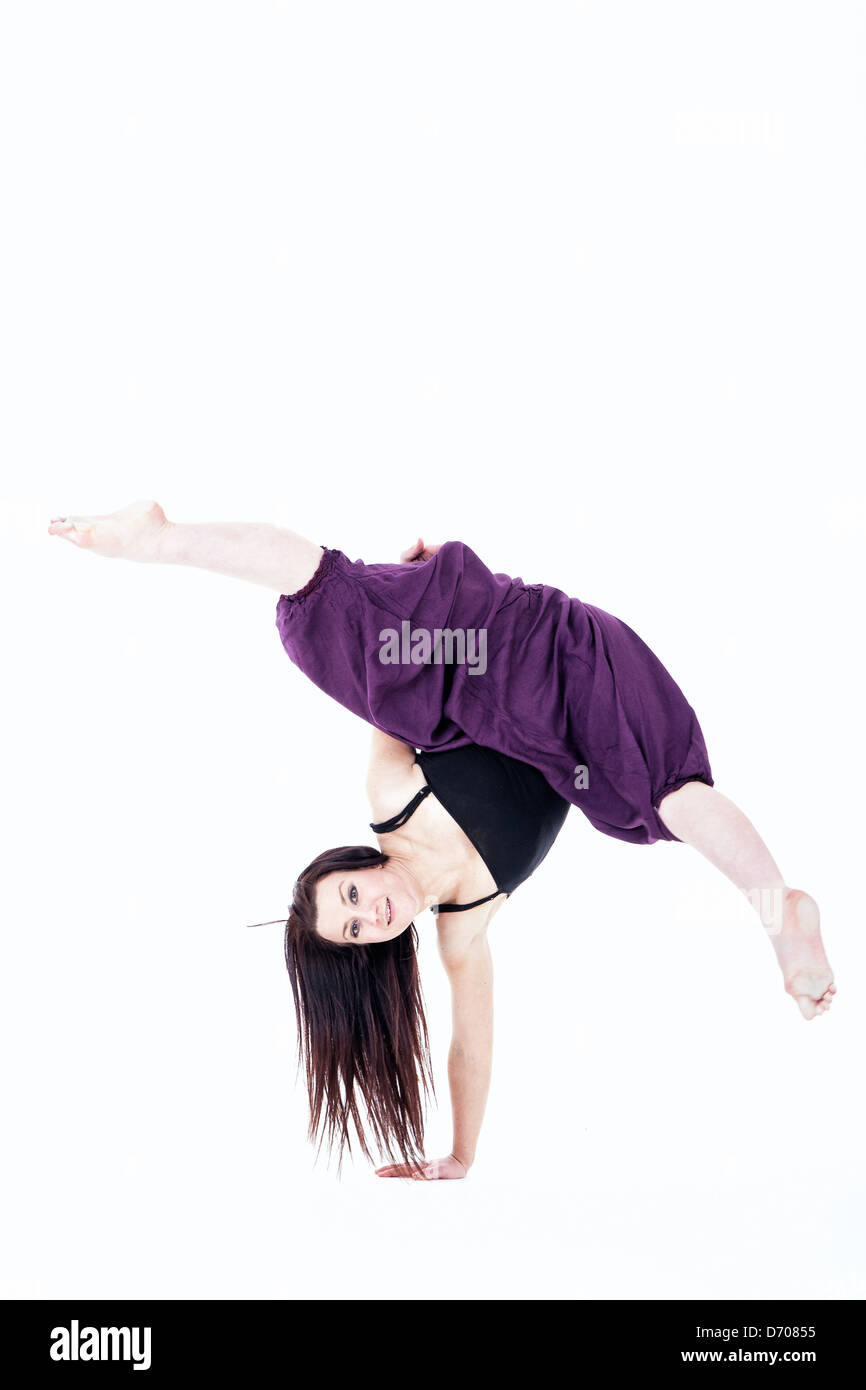 female dancer balancing on one hand with legs apart Stock Photo