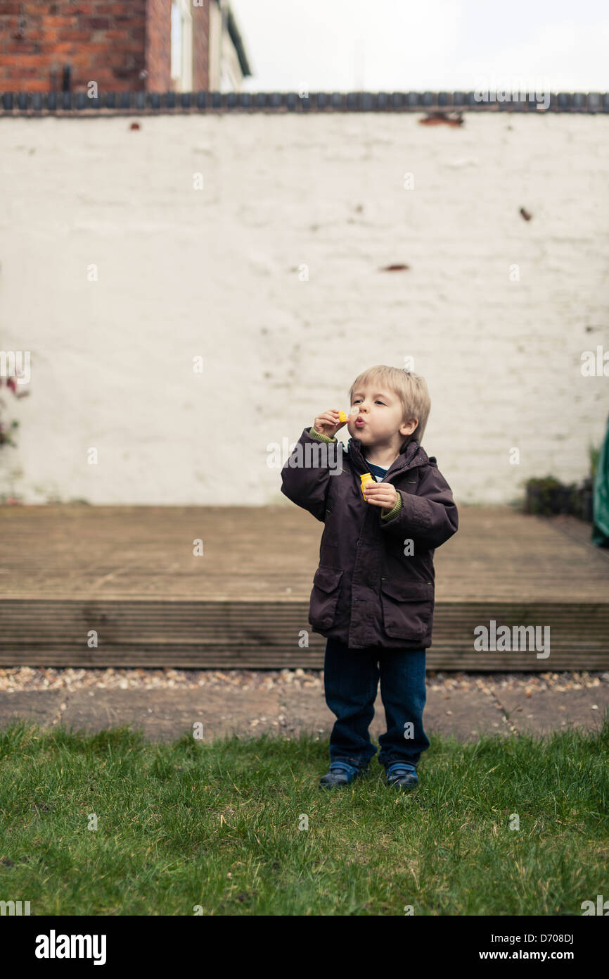 young boy blowing bubbles in the garden Stock Photo