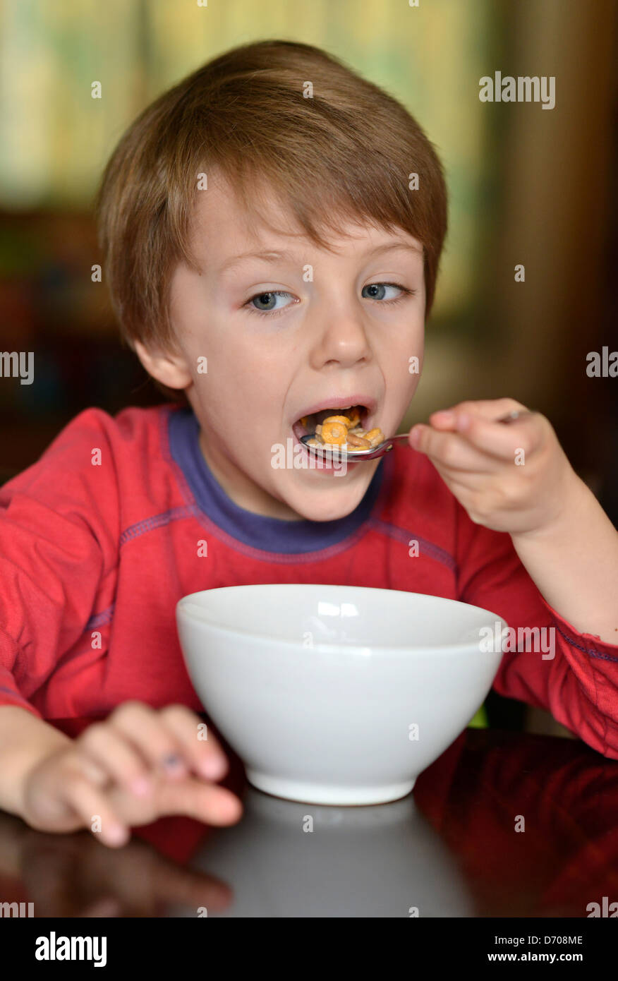A boy aged five years old, eating a bowl of cereal. Stock Photo