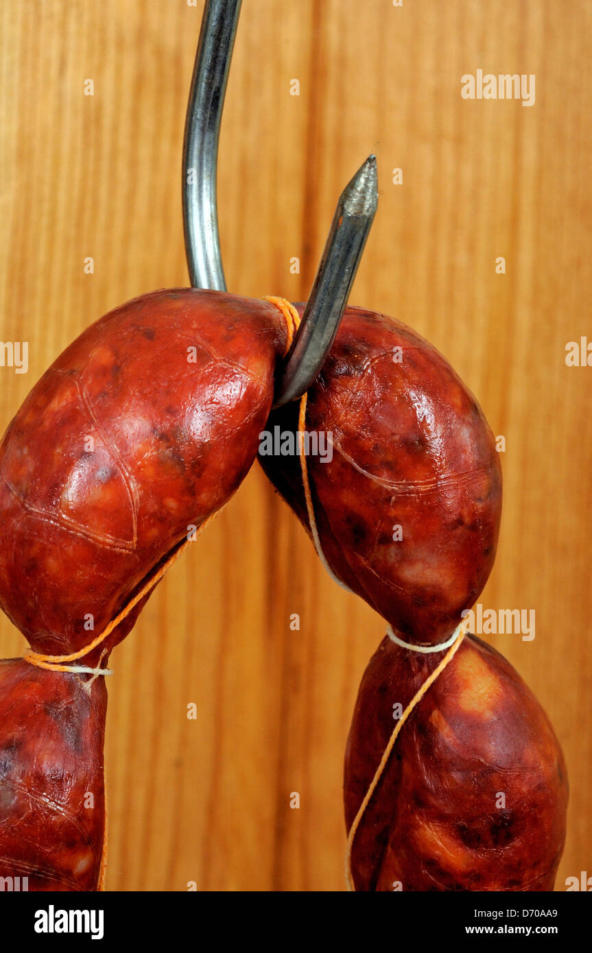 String of Spanish Chorizo sausage hanging from a meat hook. Stock Photo