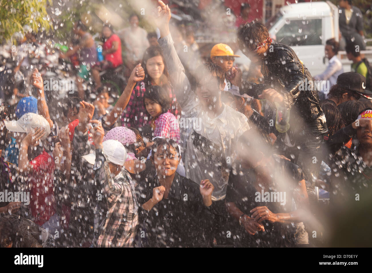 Celebrants dance in the street and get hosed with water during the Thingyan Water Festival in Mandalay, Myanmar. Stock Photo
