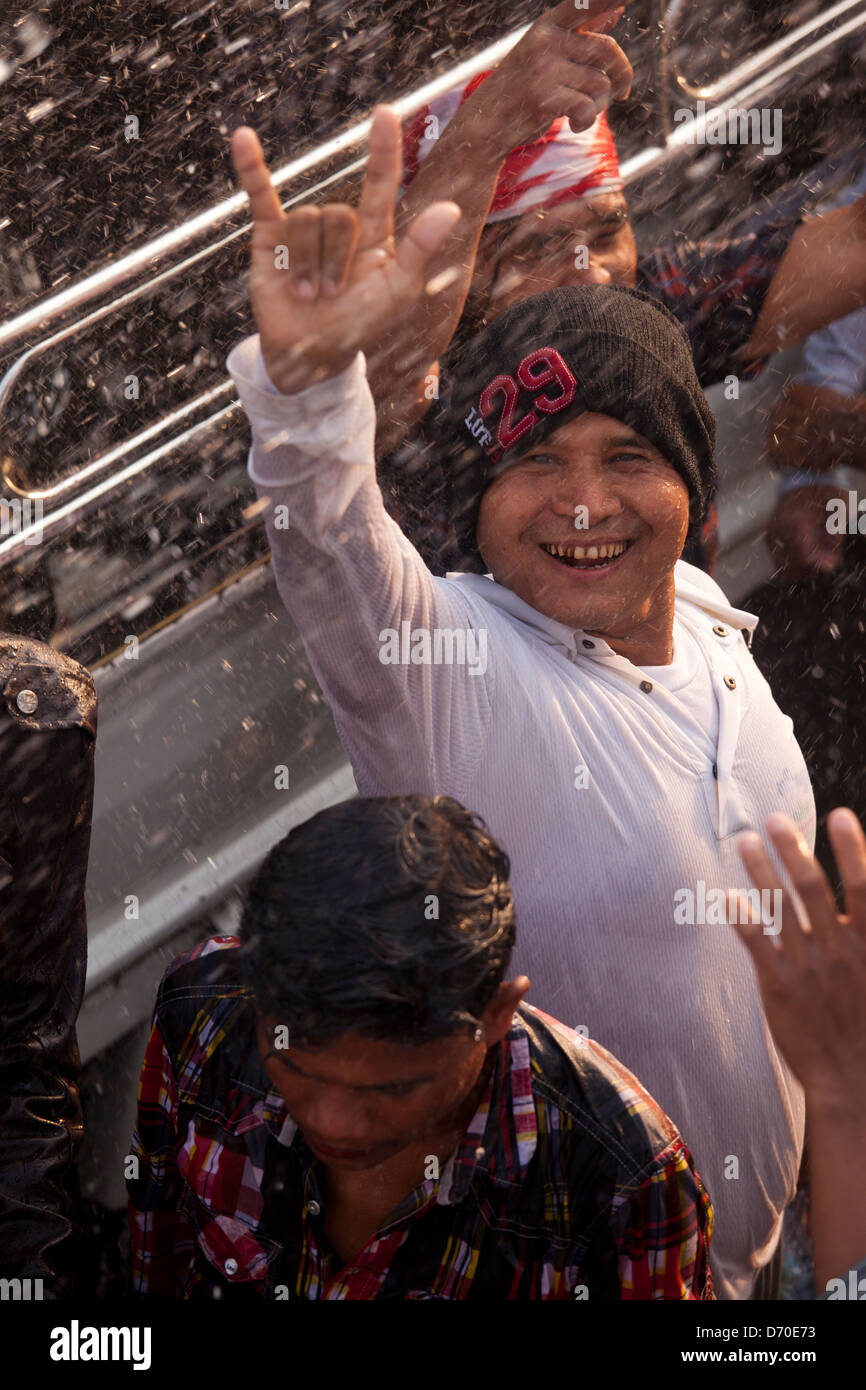 A young man celebrates the Thingyan Water Festival in Mandalay as he gets hosed with water. Stock Photo