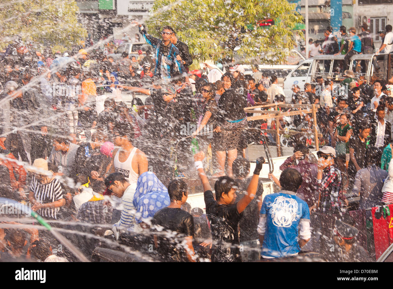 Celebrants climb atop a variety of vehicles so they can dance and get hosed during Mayanmar's Thingyan Water Festival. Stock Photo