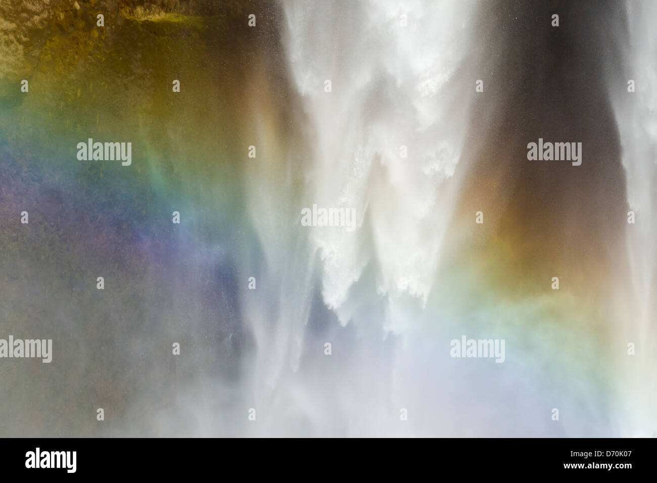 Detail of a primary rainbow showing color spectrum of visible light as droplets of water spray refract sunlight at waterfall Stock Photo