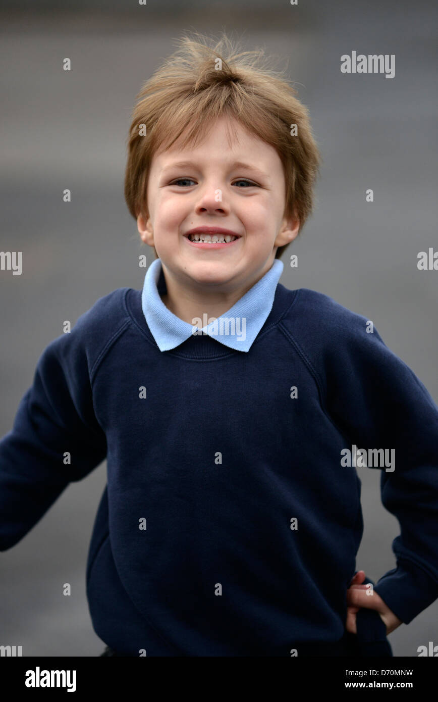 A five year old boy wearing his school uniform outside school Stock