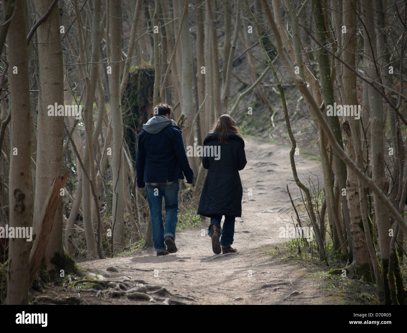 A couple walk through woods up to Chanctonbury Hill Stock Photo