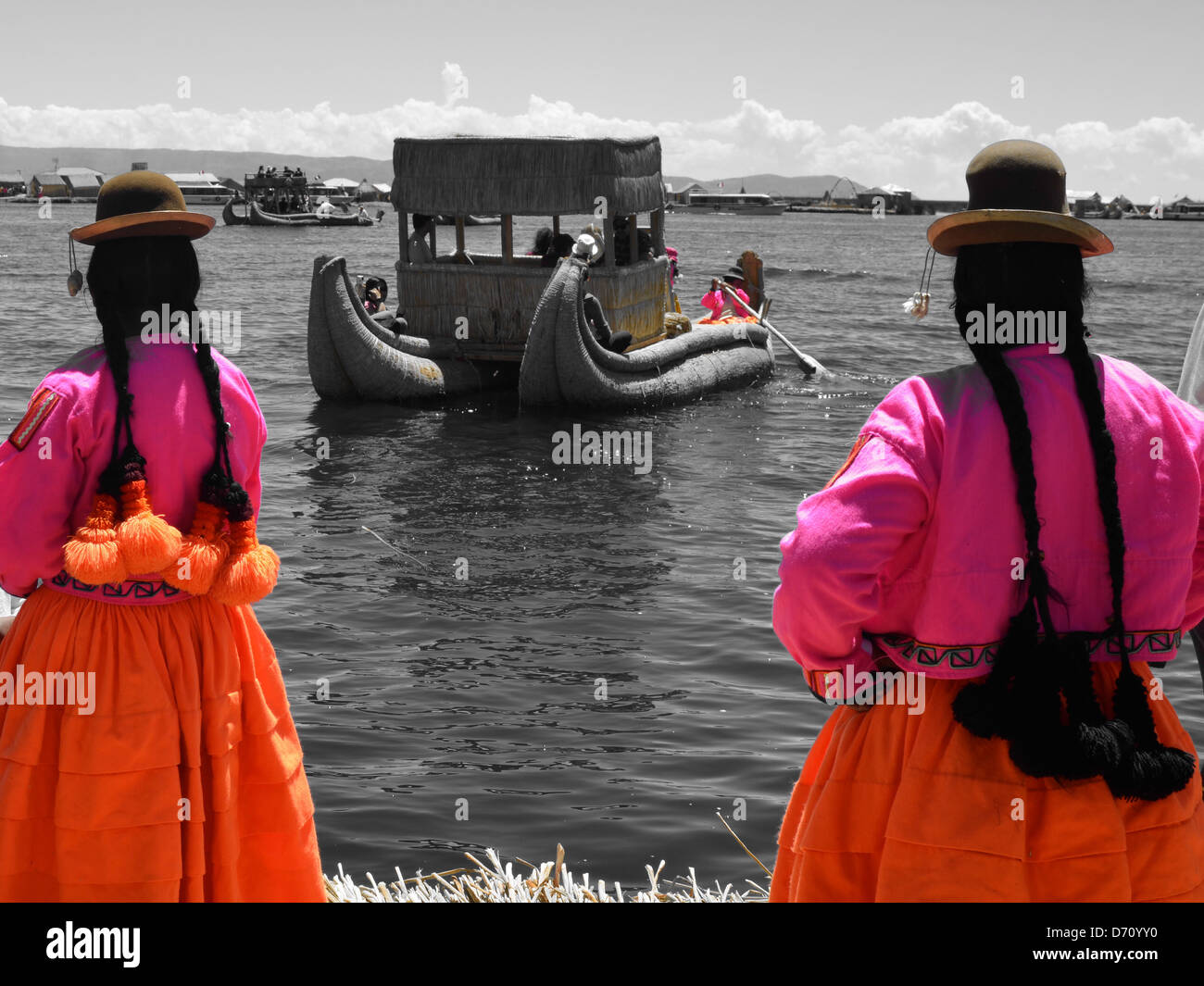 local ladies watch a reed boat sailing on Lake Titicaca, Peru Stock ...