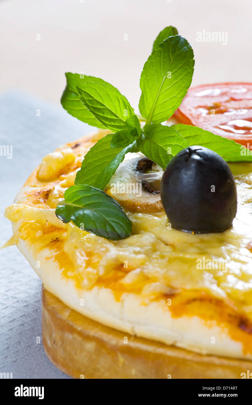 Pizza made with Salami, Mozzarella, Mushrooms, Olives and Tomato Sauce  Stock Photo