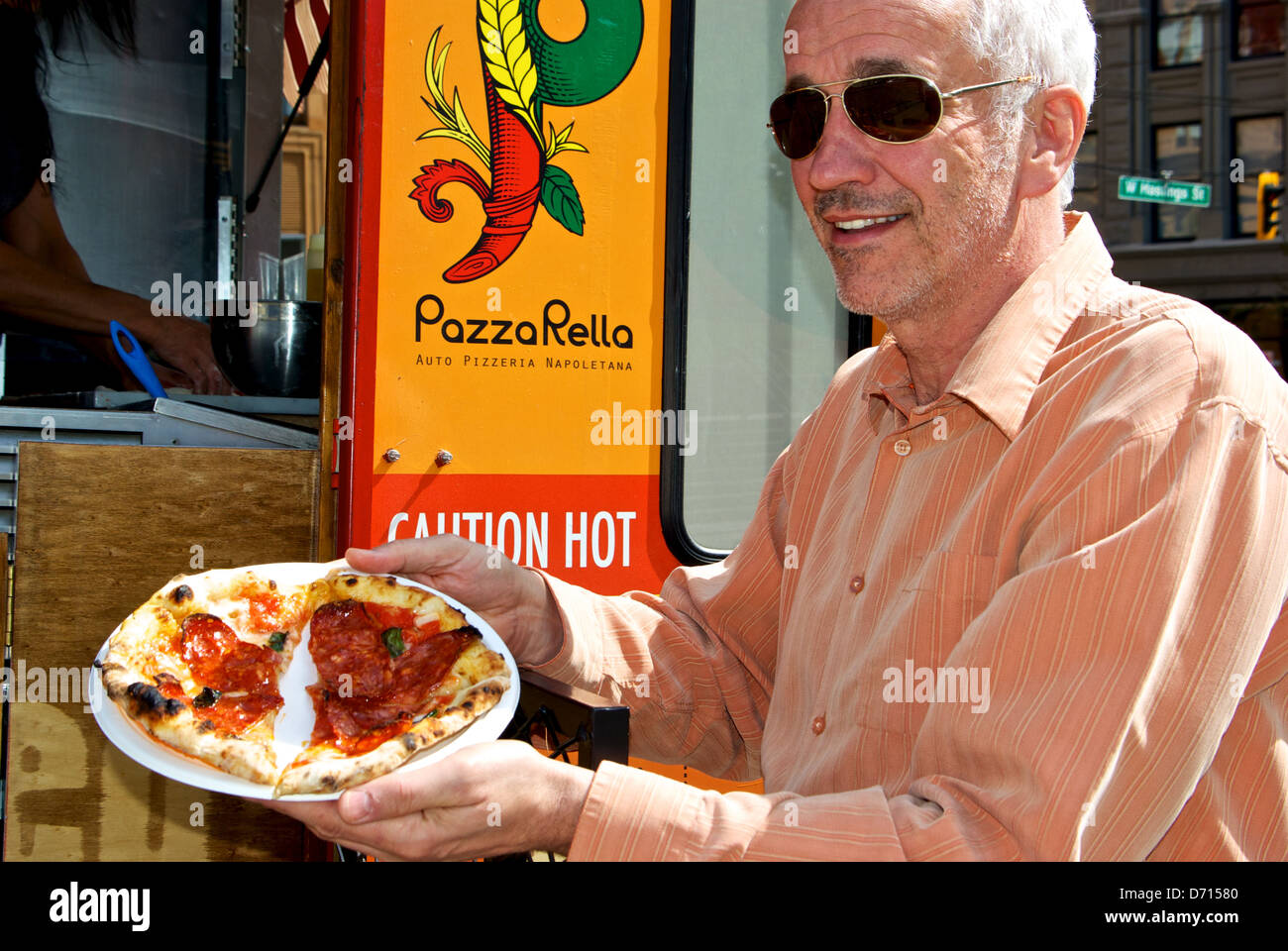 Customer PazzaRella wood fired oven pizza from retail food truck Vancouver Victory Square Hastings street Stock Photo