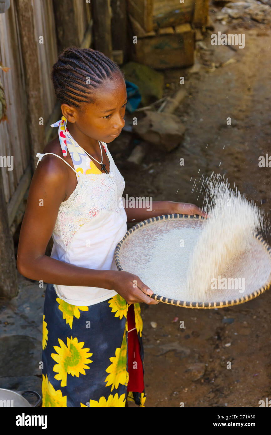 Girl winnowing rice, Nosy Be, Madagascar Stock Photo