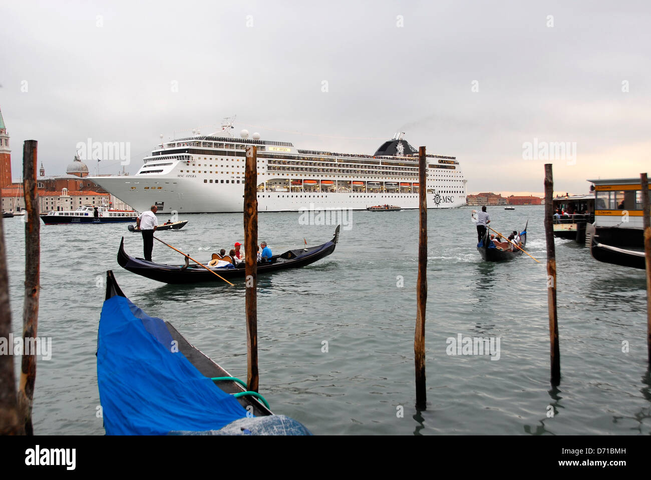 Gondolas and gondolier with the cruise ship MSC Opera in background in Venice, Italy Stock Photo