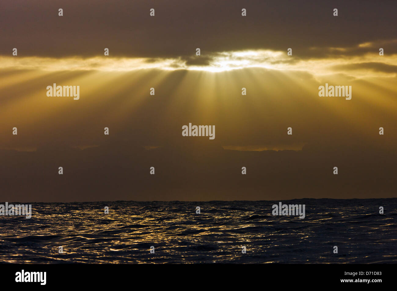 Sunlight breaking through the clouds above the ocean, False Bay, South ...