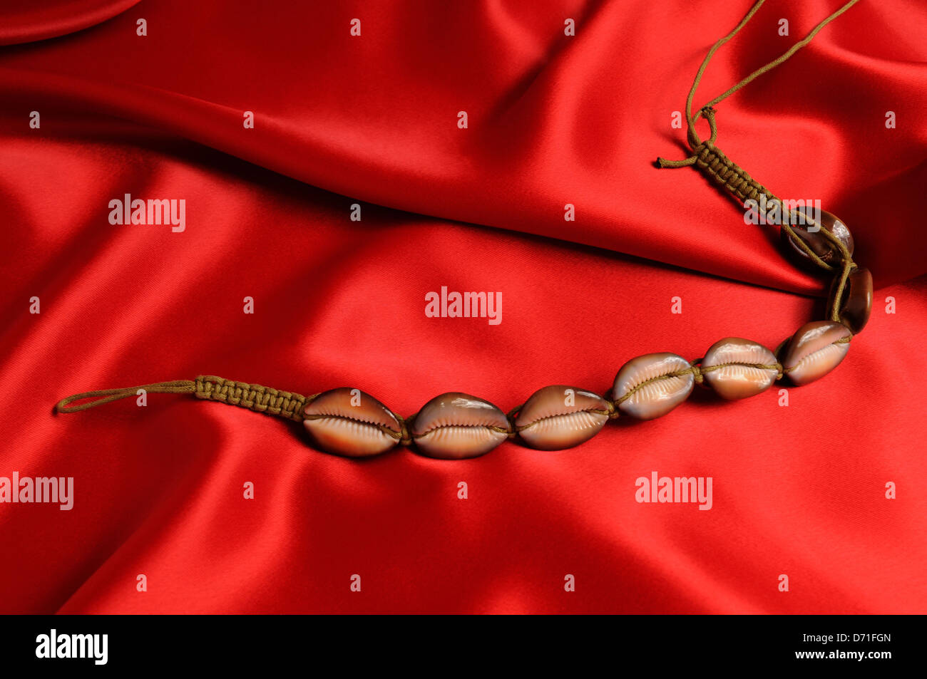 Shells necklace on red satin background. Stock Photo