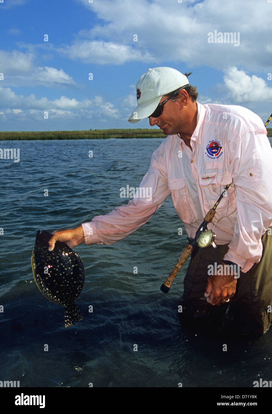 Angler releasing a Gulf Flounder (Paralichthys albiguttata) caught near