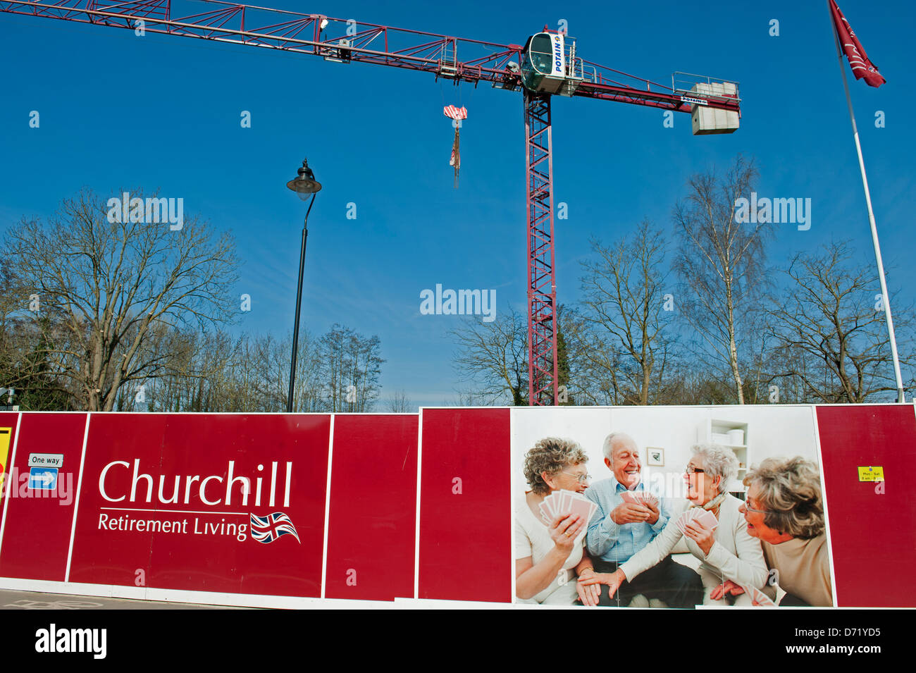 Site of new development for retirement homes with crane and advertising hoardings Stock Photo