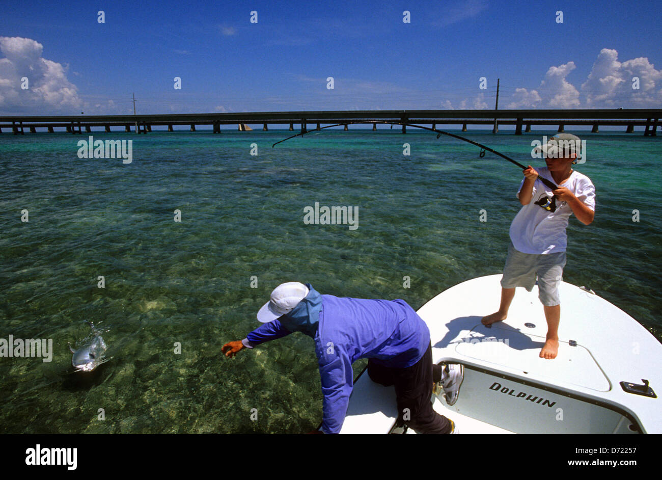 A boy and his guide landing a permit fish (Trachinotus falcatus) near Marathon in the Florida Keys Stock Photo