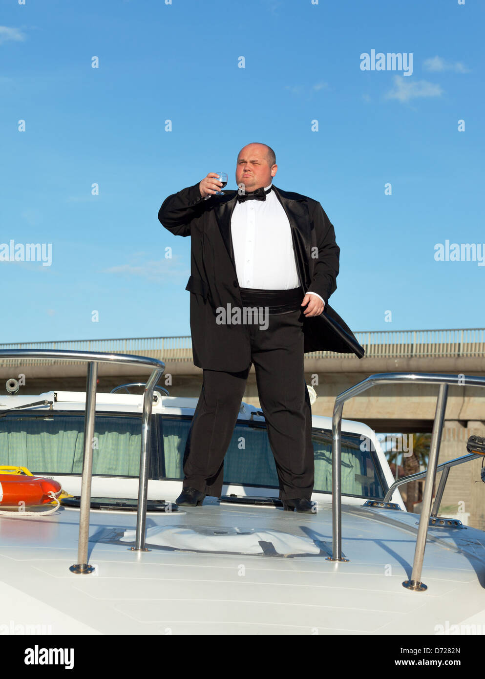 Overweight man in tuxedo standing on the deck of a luxury pleasure boat