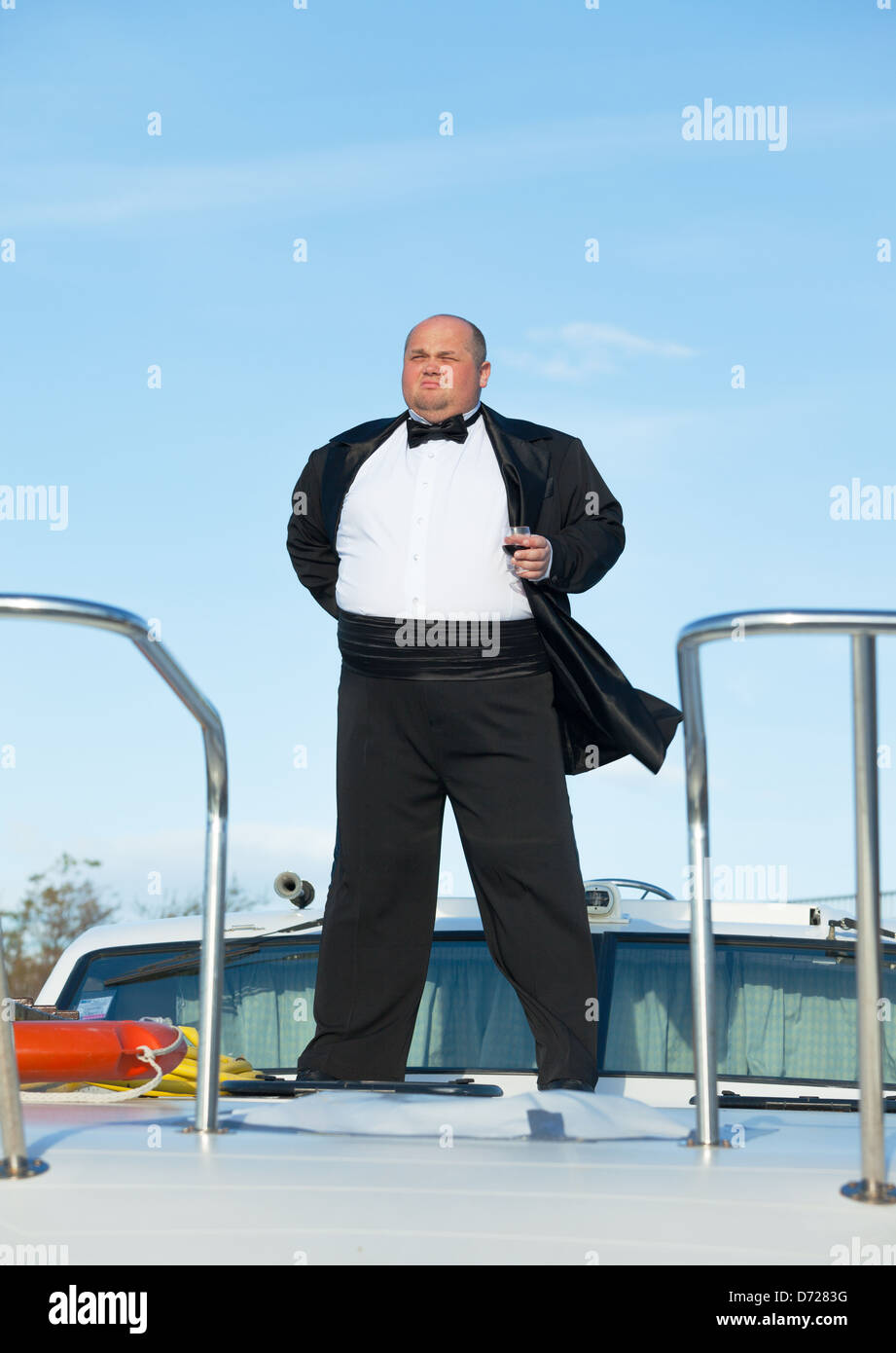 Overweight man in tuxedo standing on the deck of a luxury pleasure boat