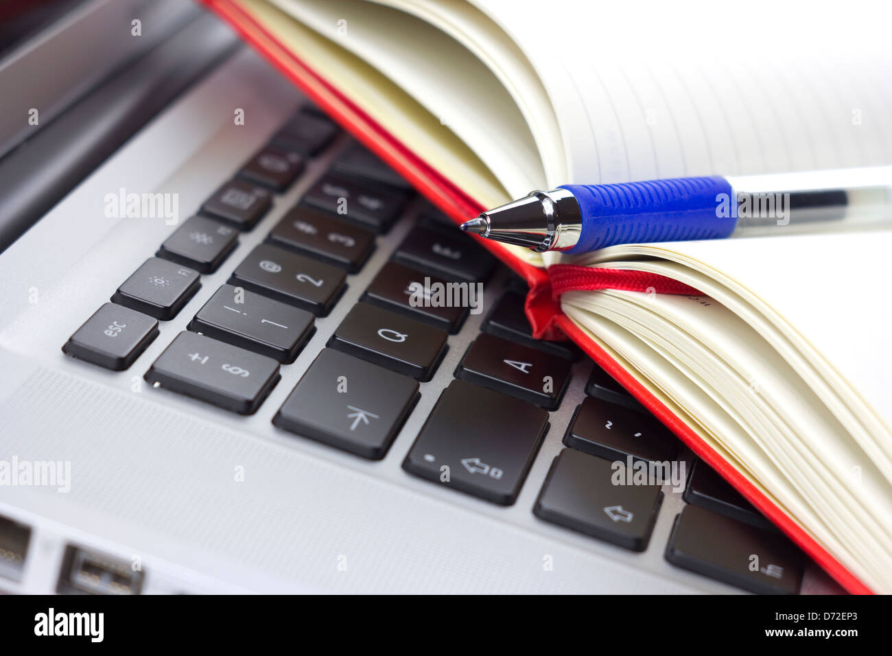 Red calendar or organizer or notebook and pen on the laptop Stock Photo
