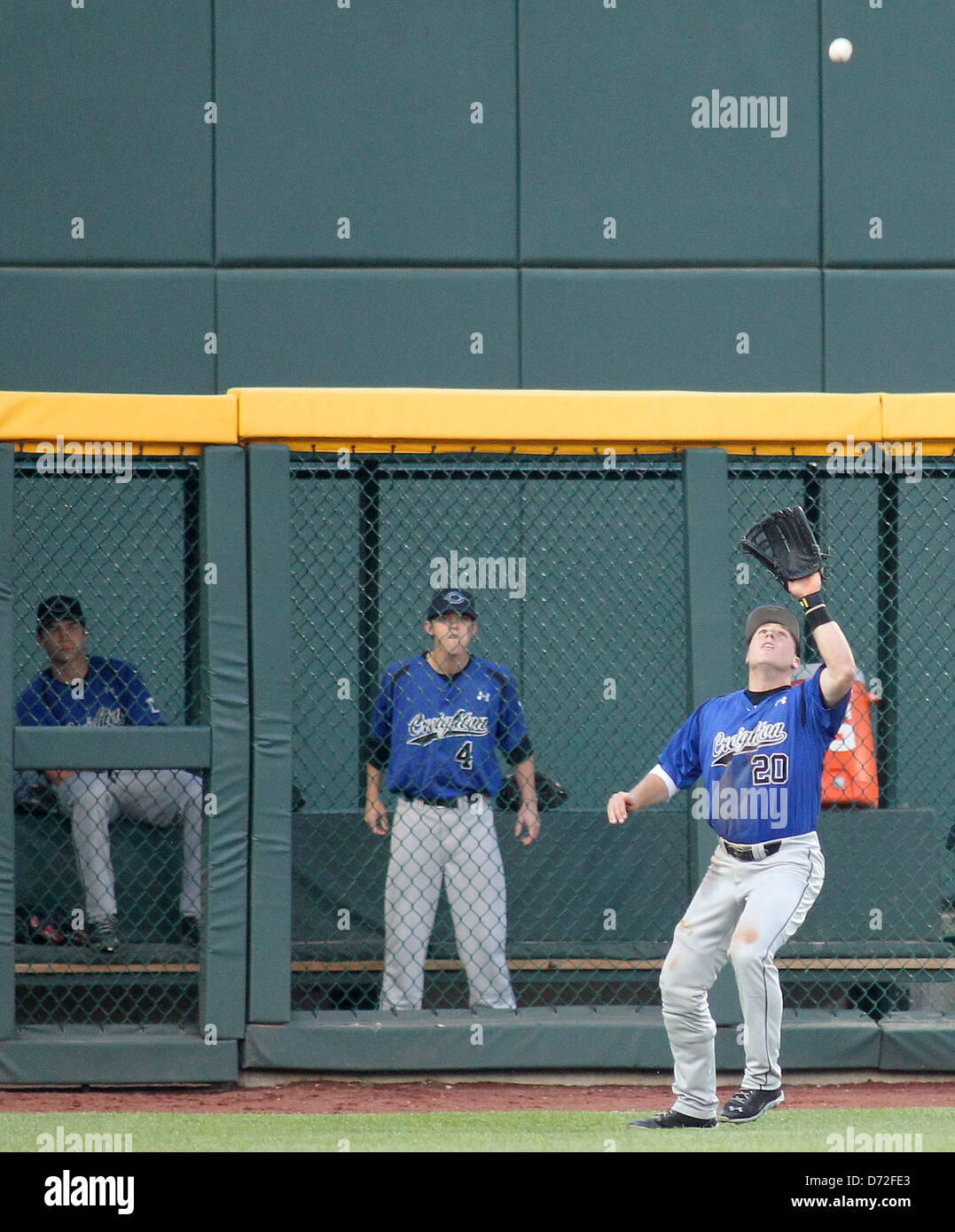 April 26, 2013 - Omaha, Nebraska, United States of America - April 26, 2013: Left fielder Michael Blatchford #20 of Creighton University catches a fly ball as teammate Brian Sova #4 watches from the bullpen in action during an NCAA Baseball game between Creighton University Bluejays and Nebraska Cornhuskers at TD Ameritrade Park in Omaha, NE...Creighton defeated Nebraska 5-3 Stock Photo