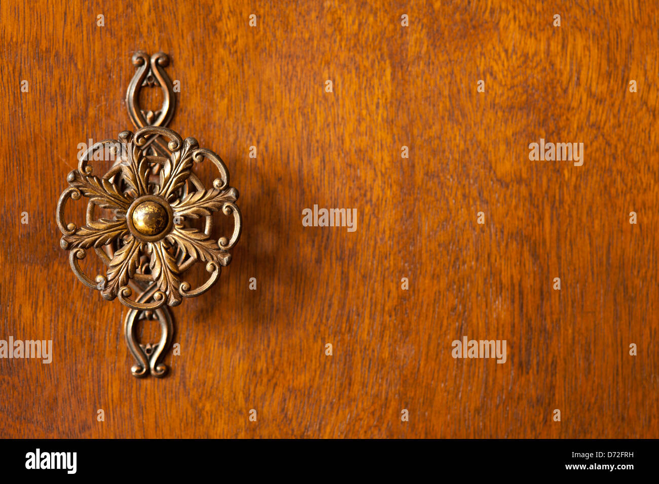 detail of wardrobe door or wooden brown background with decorative knob on left side Stock Photo
