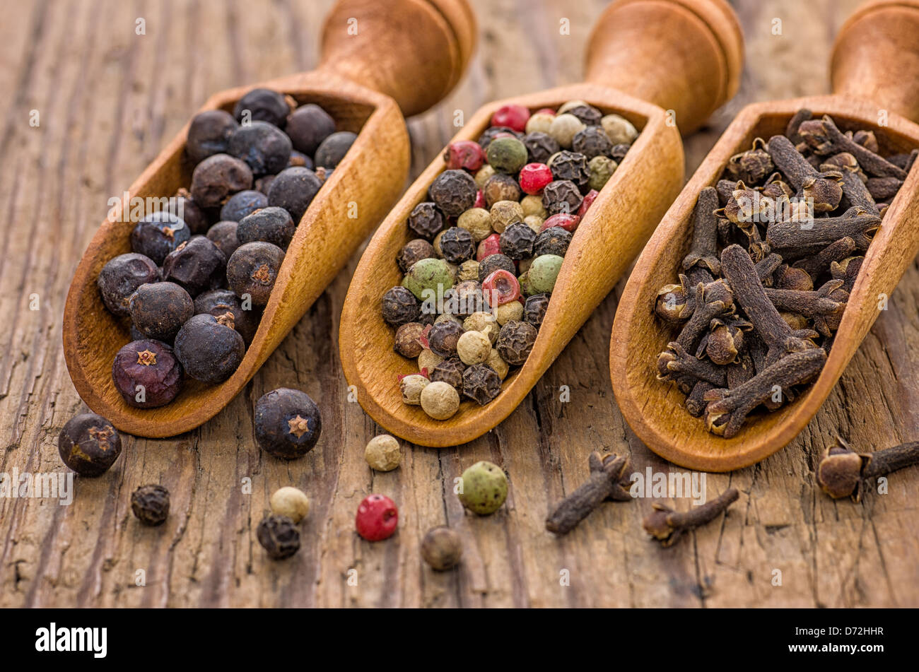 Spice scoops with juniper berries, pepper and cloves Stock Photo Alamy