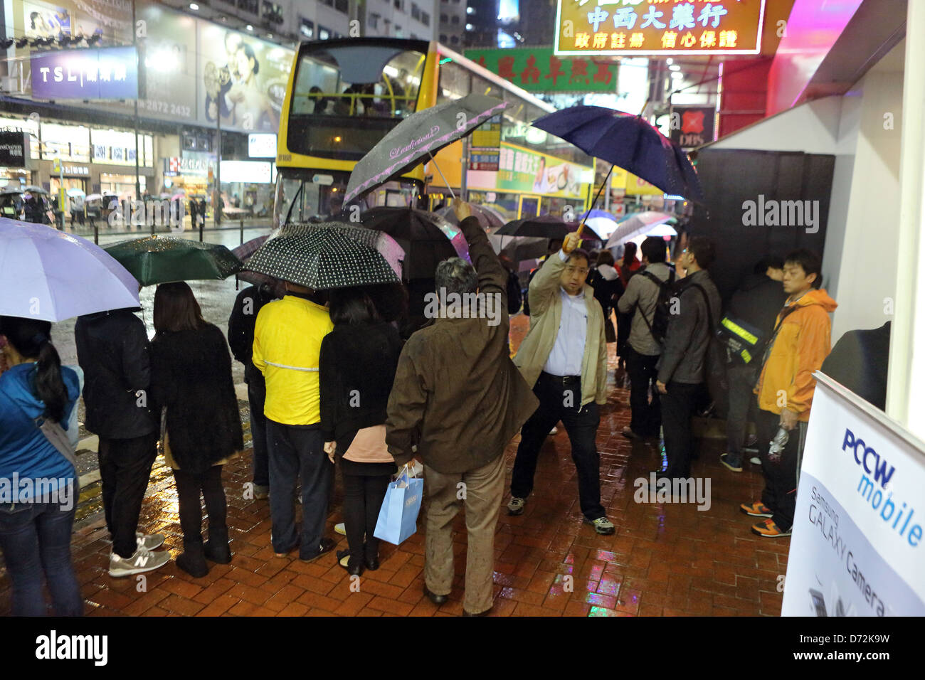 Hong Kong, China, People stand in the rain at a bus stop Stock Photo