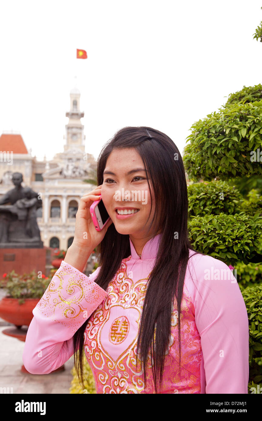 Ho Chi Minh City, Vietnam, woman in traditional dress in front of the ...