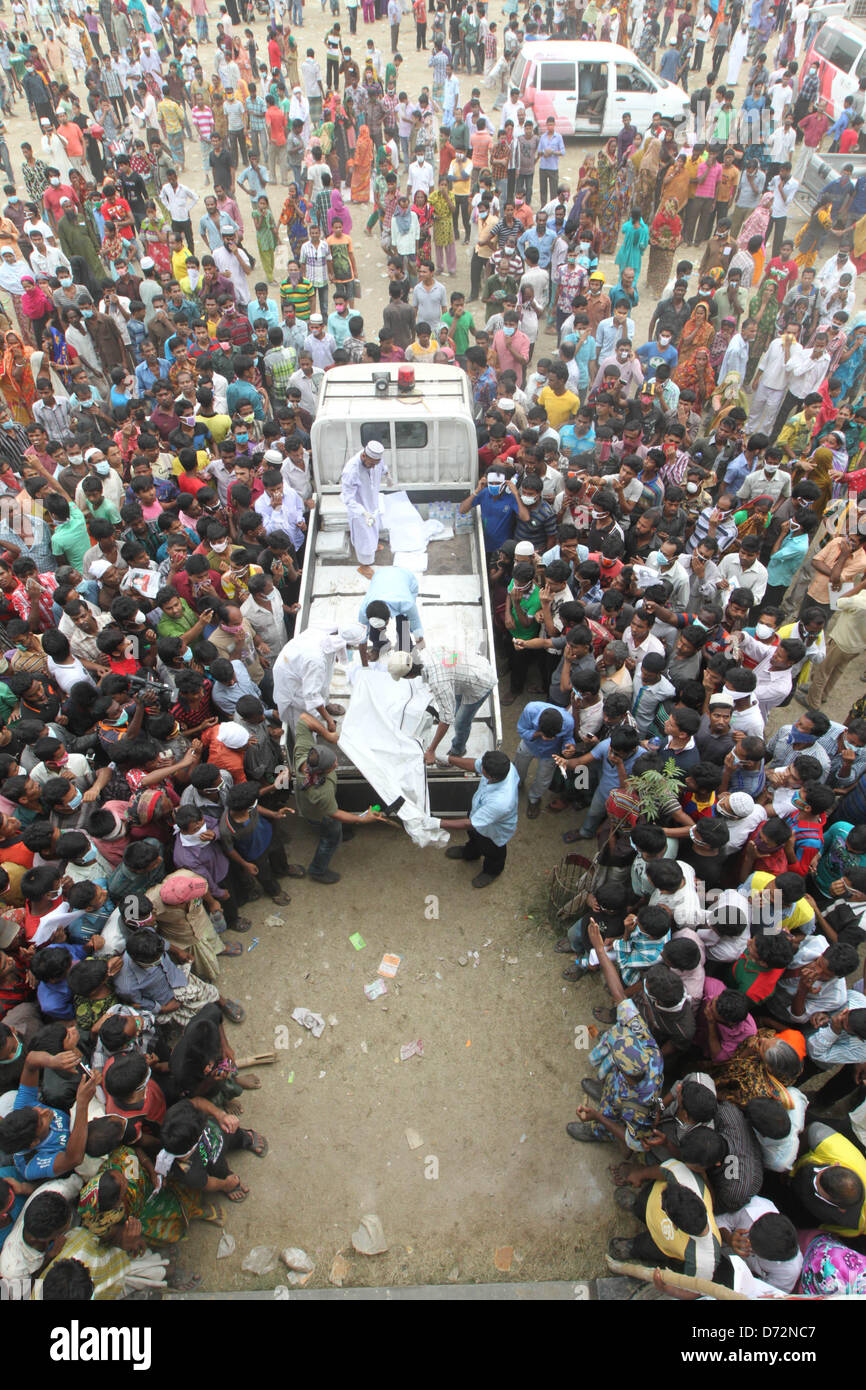 Savar, Bangladesh. April 27, 2013. - Relatives of still missing workers gather around a pickup van laying out bodies for identification, in a play ground at Savar, Bangladesh 27 April 2013. Death toll rises to 341 of the eight-storey building Rana Plaza which collapsed at Savar, outside Dhaka, Bangladesh, 25 April 2013. Many more were still trapped in the remains of the building, which also contained shops and offices, and the army had been called in to help with rescue operations, police said. (Credit Image: Credit:  Monirul Alam/ZUMAPRESS.com/Alamy Live News) Stock Photo