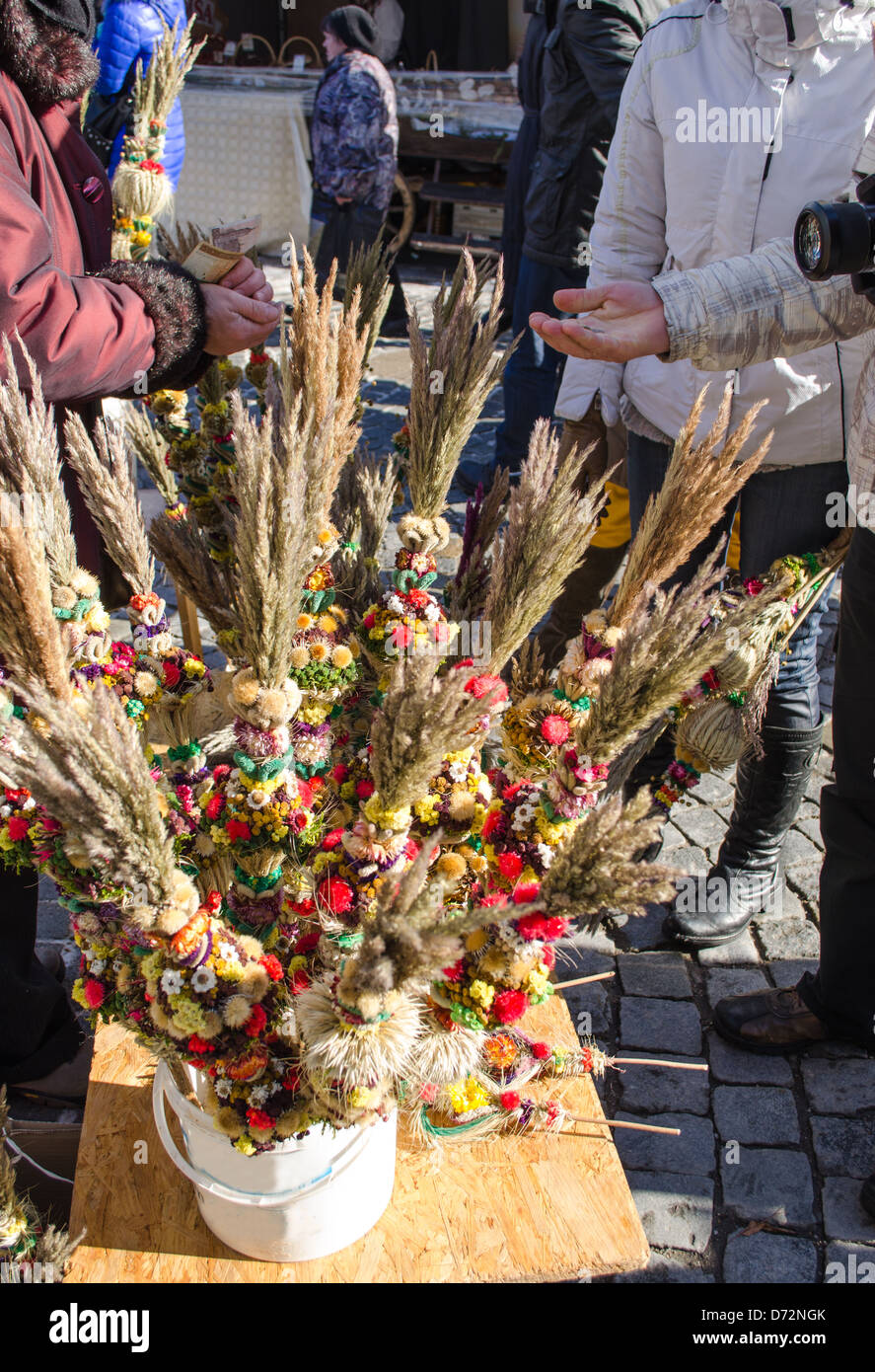 people buy traditional floral natural palm decorations for money in outdoor spring market fair event. Stock Photo