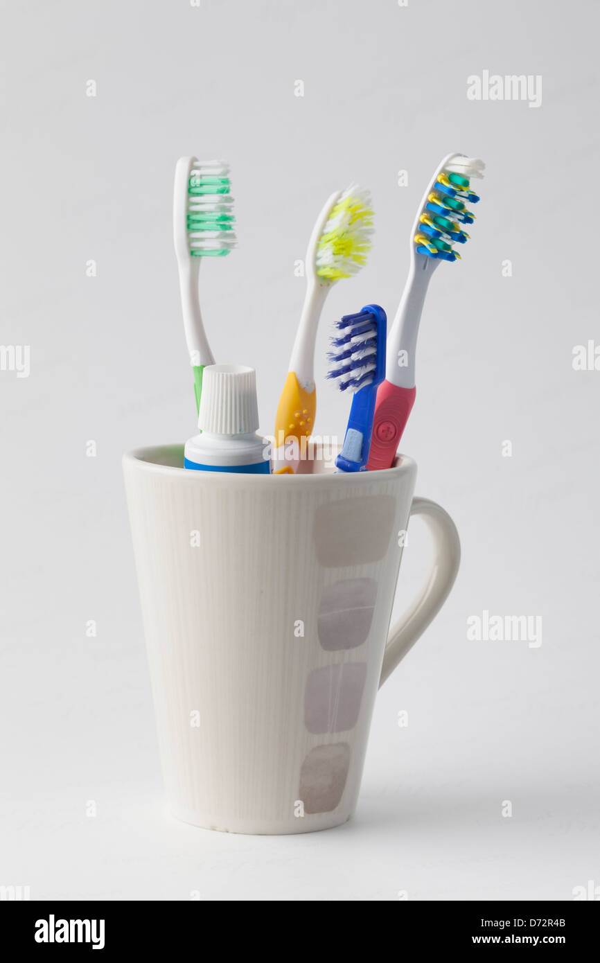 Toothbrushes and toothpaste in a mug Stock Photo