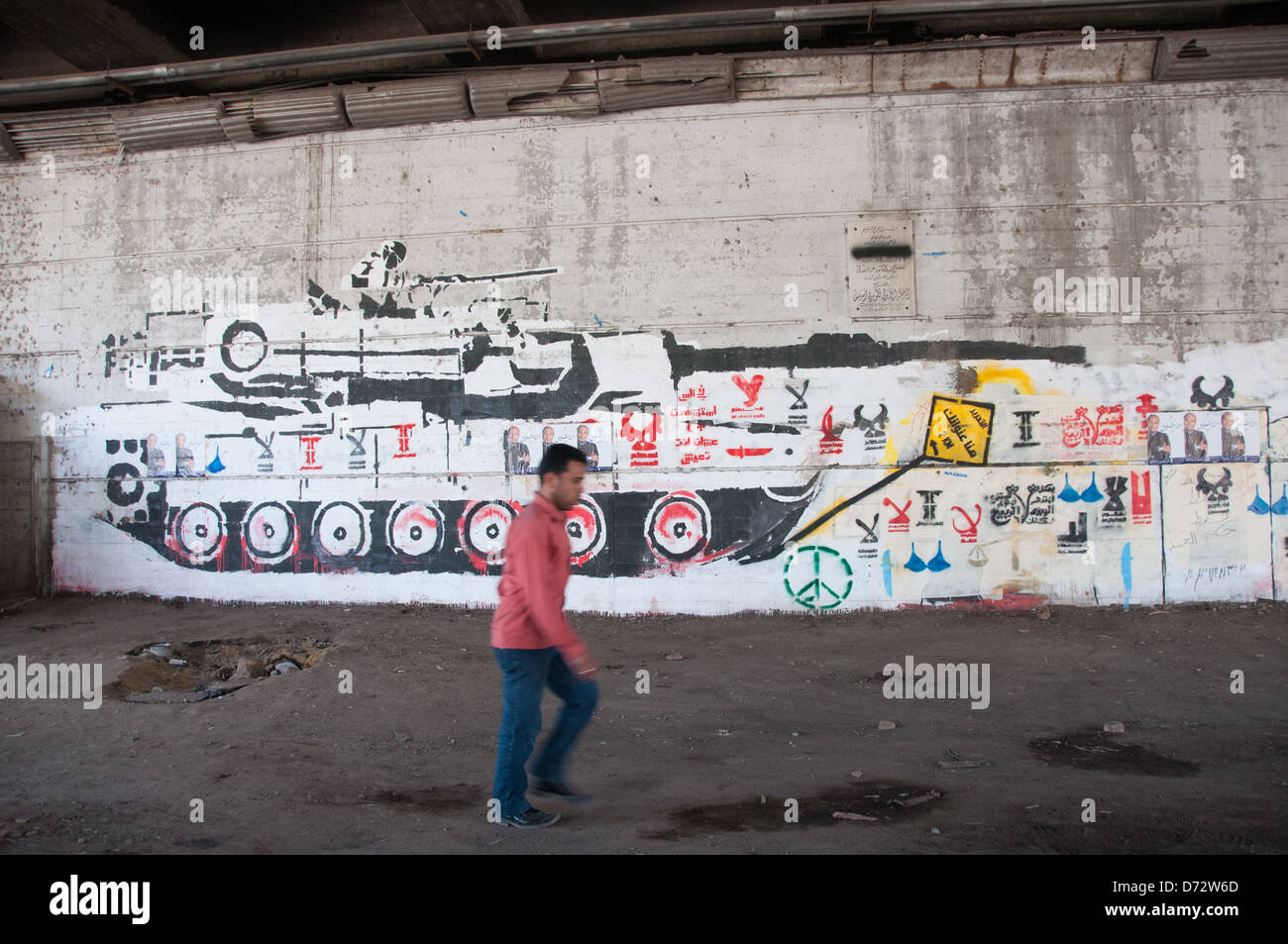 Man walking in front of Pro-Revolutionary murals Zamalek Cairo Egypt Stock Photo