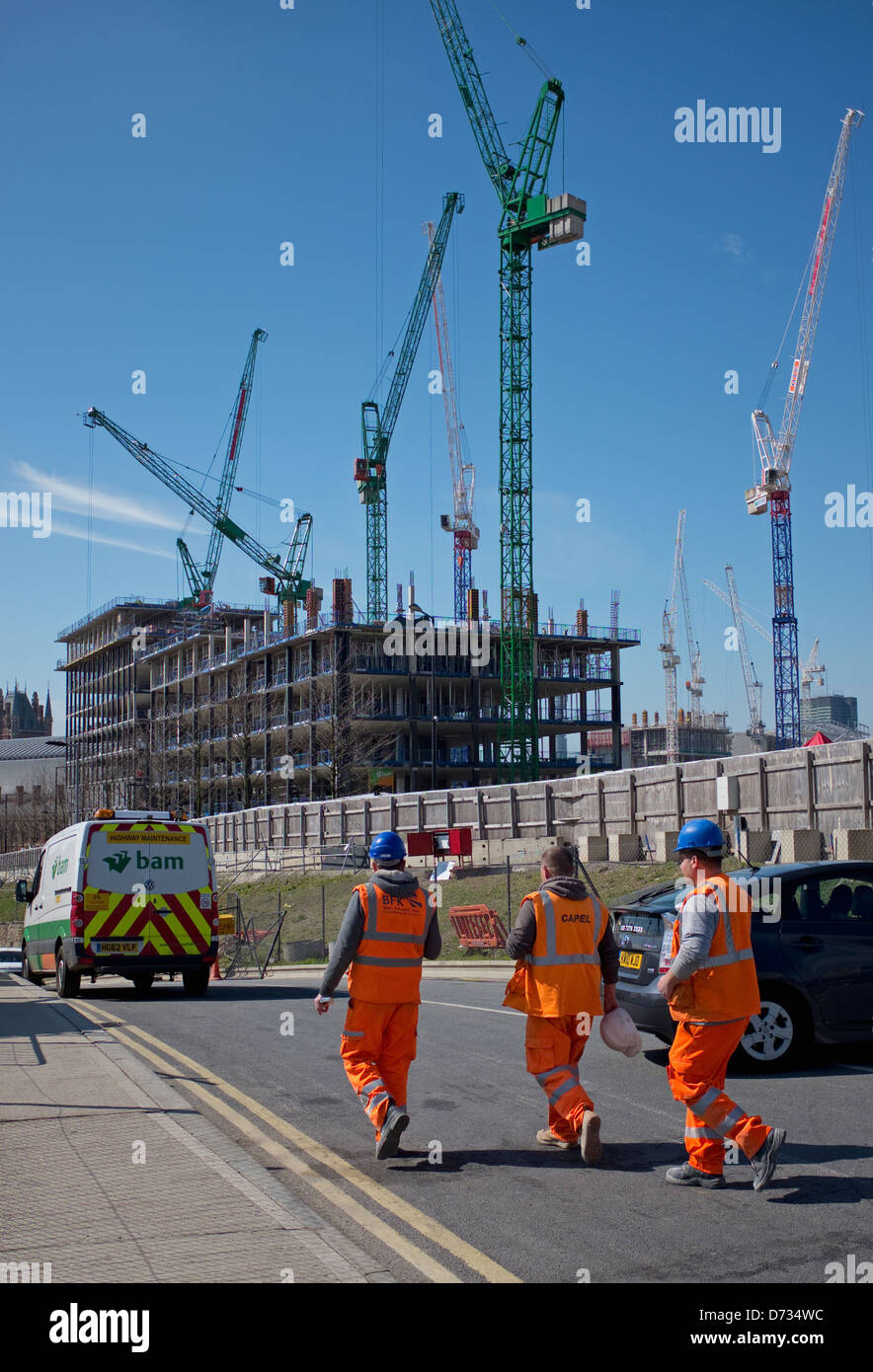 Three construction workers wearing high visibilty safety clothing at Kings Cross, London Stock Photo
