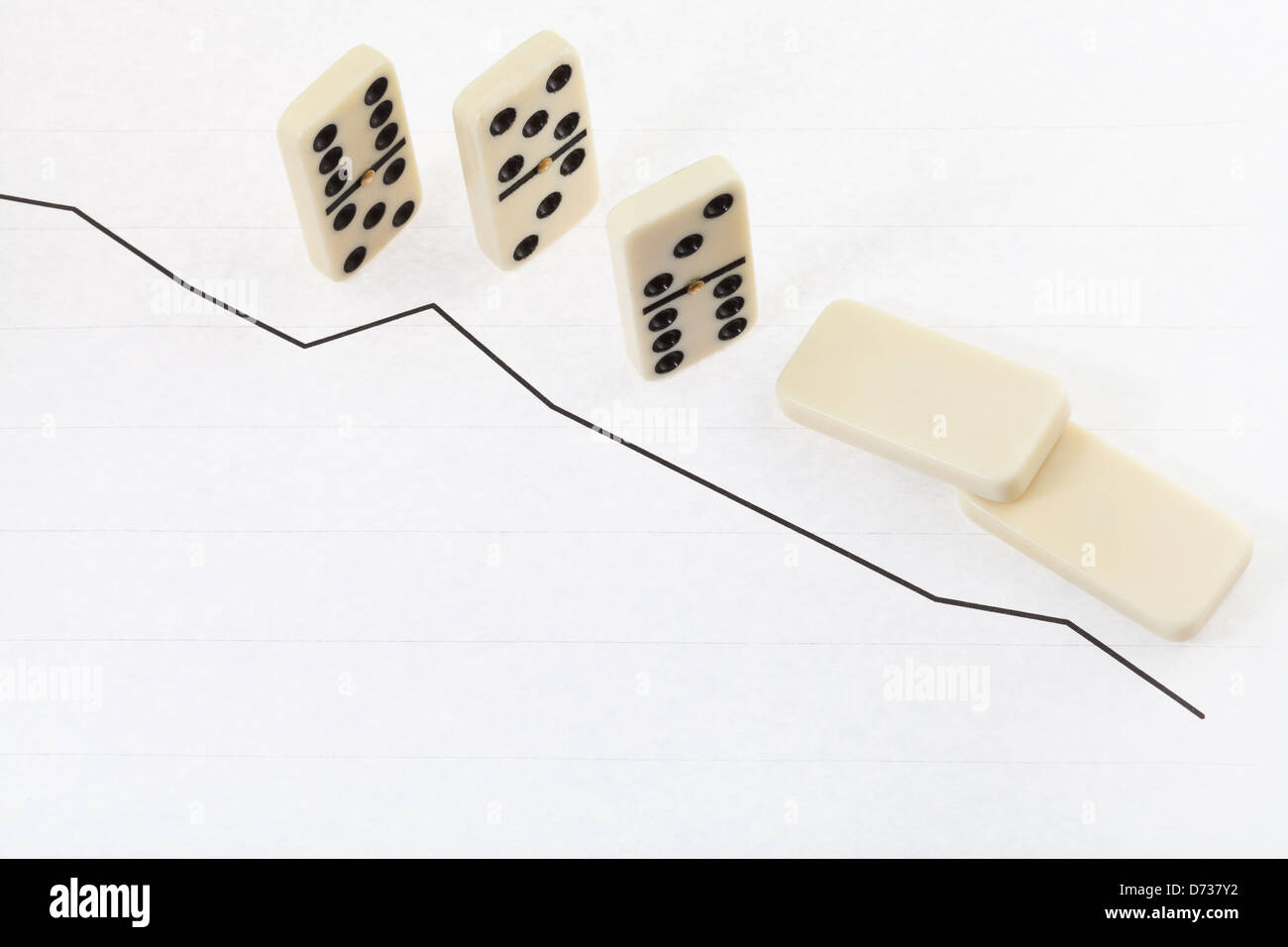 business concept - falled domino and graph of decline results Stock Photo