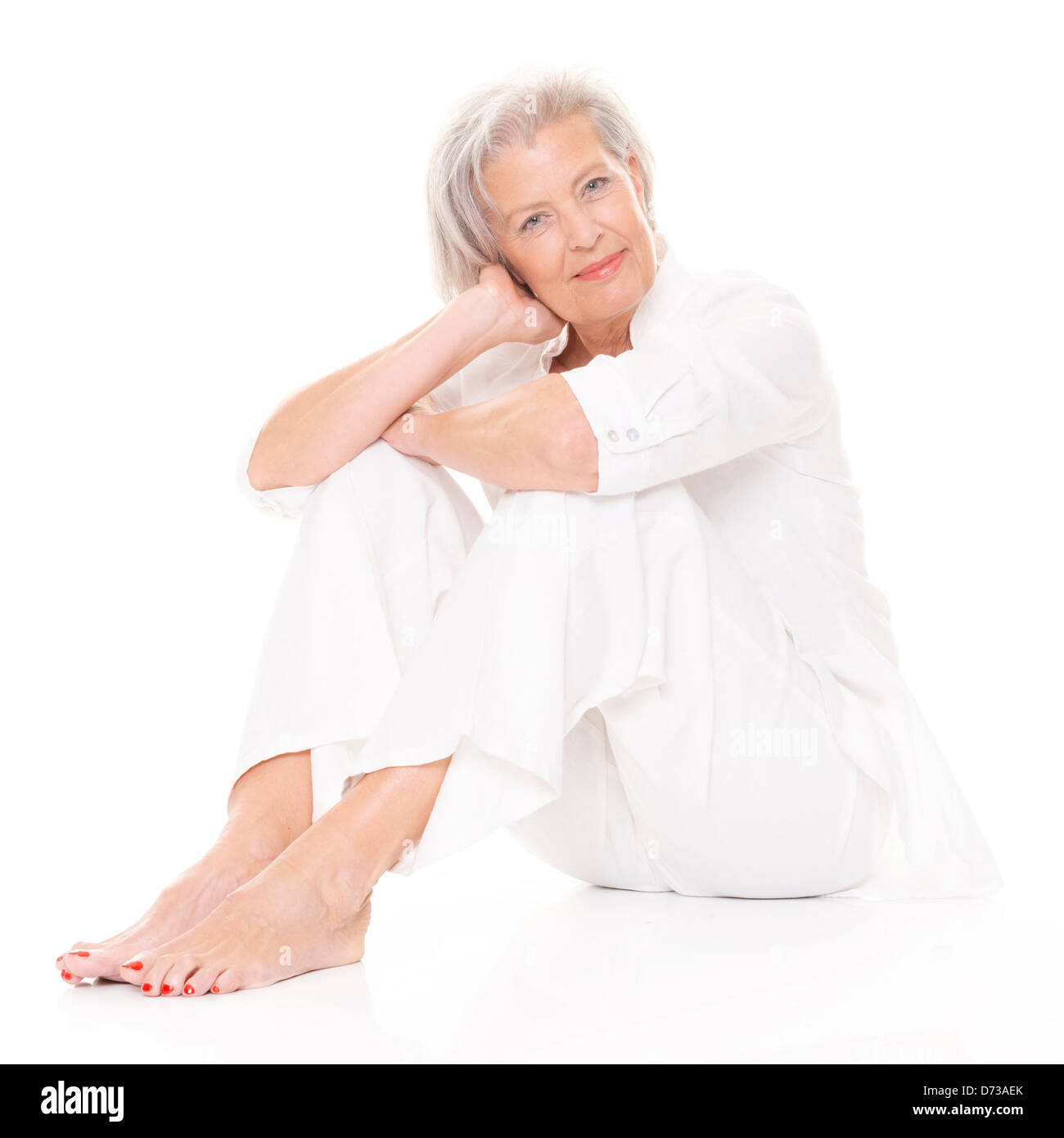 Sitting senior woman in front of white background Stock Photo - Alamy