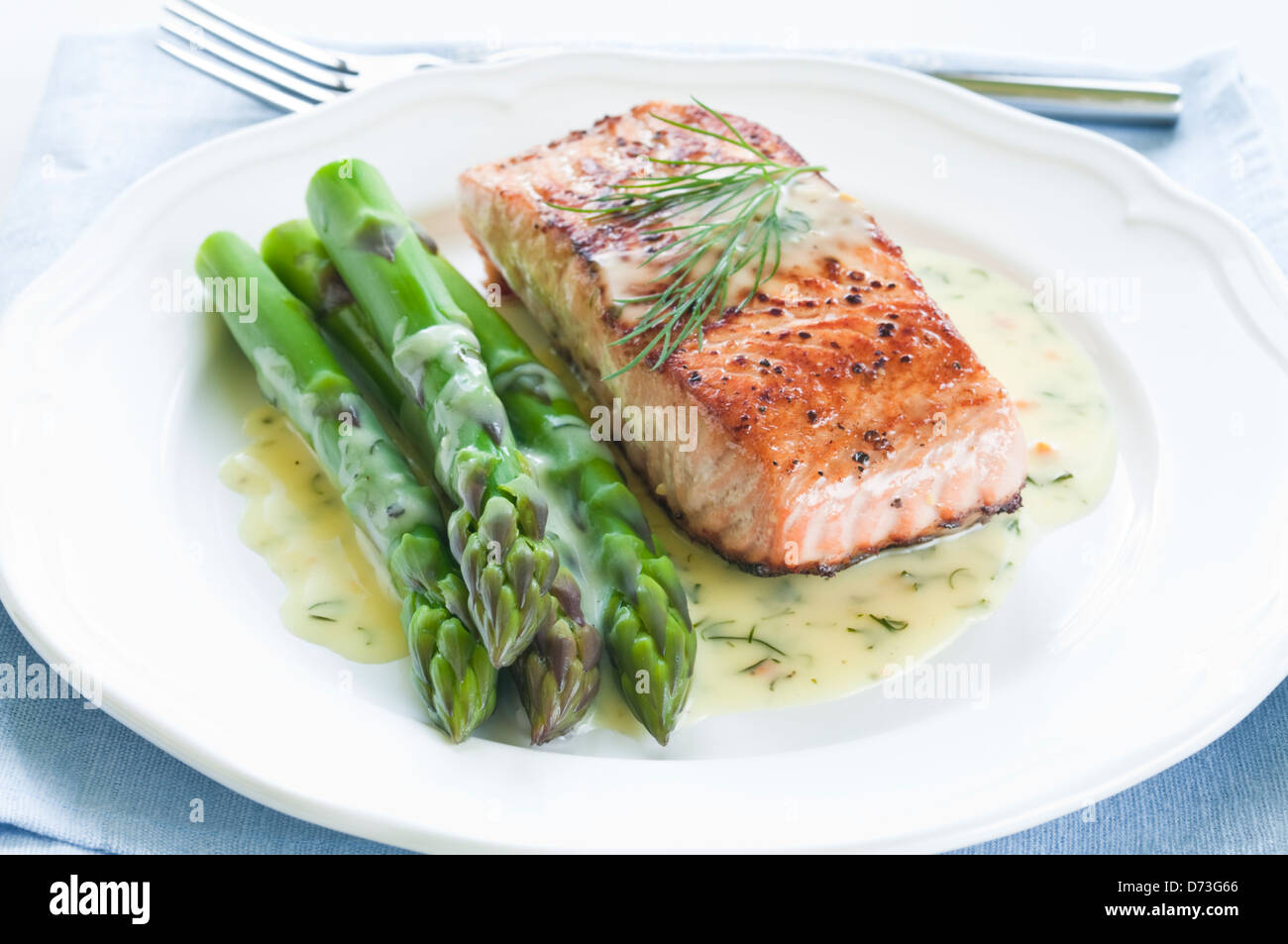 Grilled salmon with asparagus and dill sauce on white plate Stock Photo
