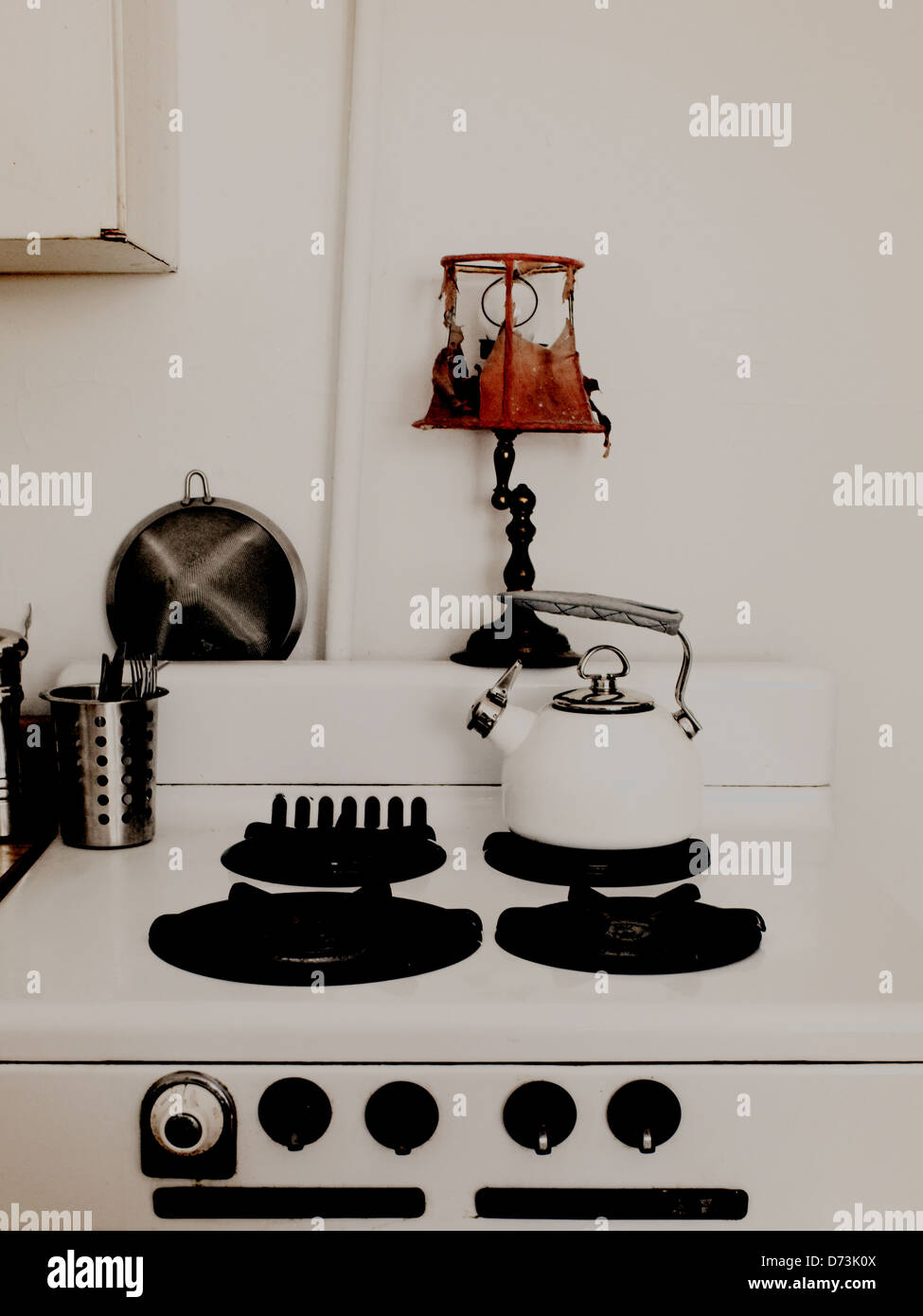 Oven, old oven, white teapot, old lamp, white wall, depressing, sad Stock Photo
