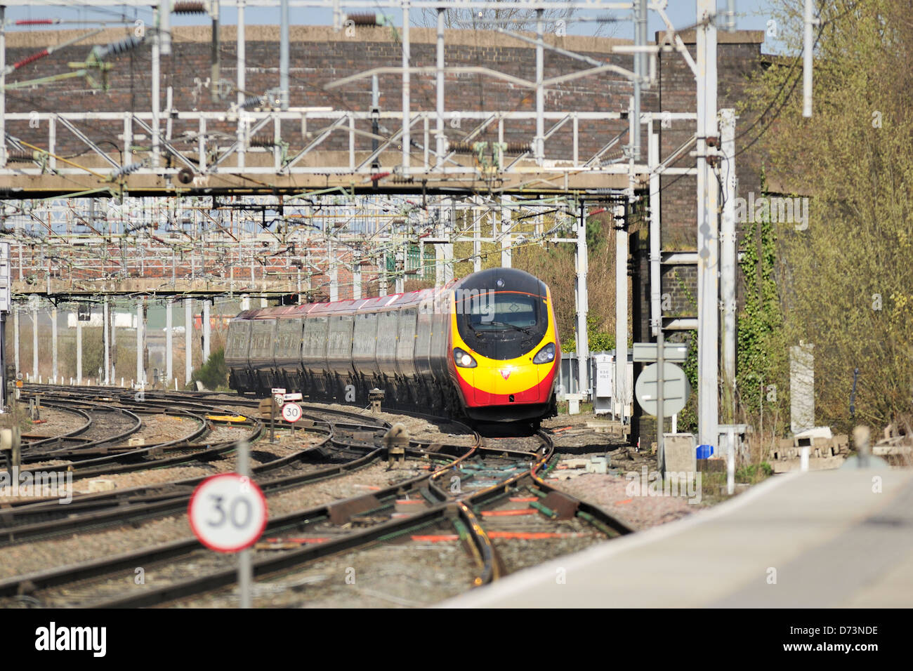 Virgin pendolino express passenger train tilting on the approach to