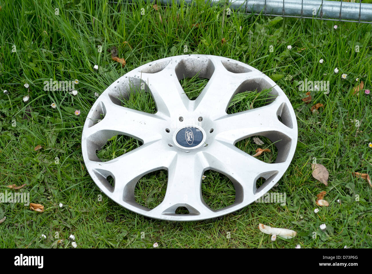 Discarded Ford car wheel trim on grass Stock Photo
