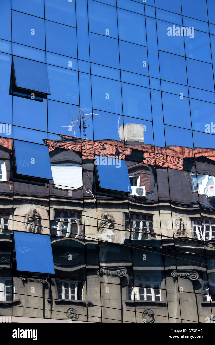 The reflection of an old building at the modern glass facade Stock Photo